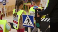 zdjęcie przedstawia dzieci biorące udział w poznawaniu znaków drogowych